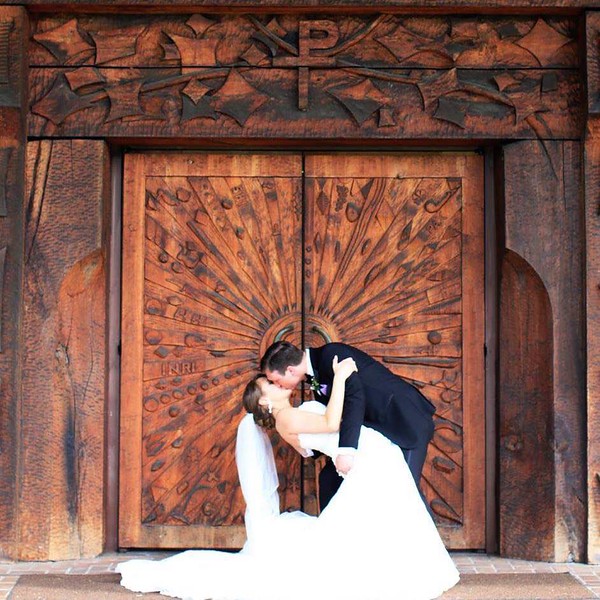 New couple kiss in front of chapel doors